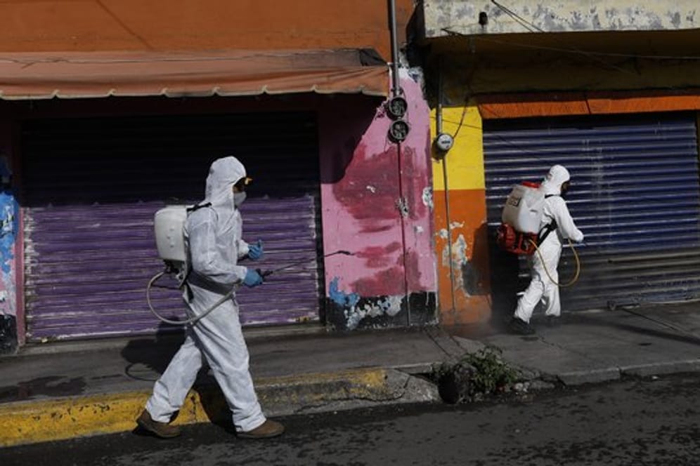 Coronavirus-Pandemie: In Mexiko-Stadt sprühen Arbeiter eine Desinfektionslösung auf die Straße.
