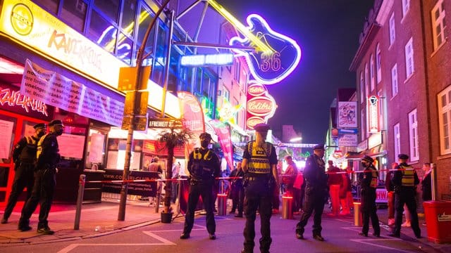 Polizisten kontrollieren den Zugang zur Großen Freiheit: Trotz Corona-Pandemie treffen sich hier viele Menschen zum Feiern. Polizisten kontrollieren den Zugang zur Großen Freiheit: Trotz Corona-Pandemie treffen sich hier viele Menschen zum Feiern.