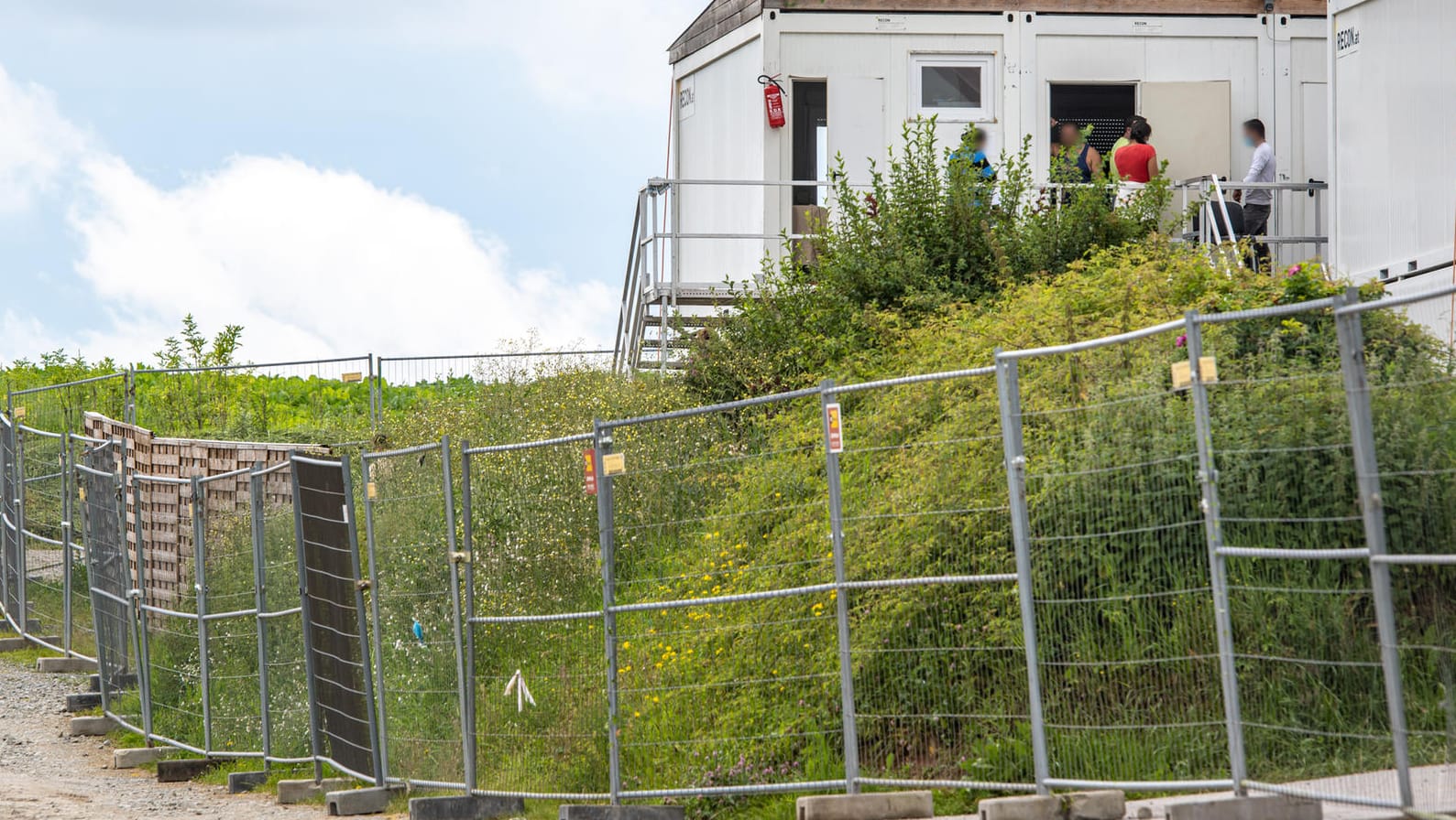 Die Unterkünfte der Erntehelfer sind mit einem Zaun gesichert: Nach einer Corona-Masseninfektion auf dem Hof in Mamming stehen fast 500 Menschen unter Quarantäne.