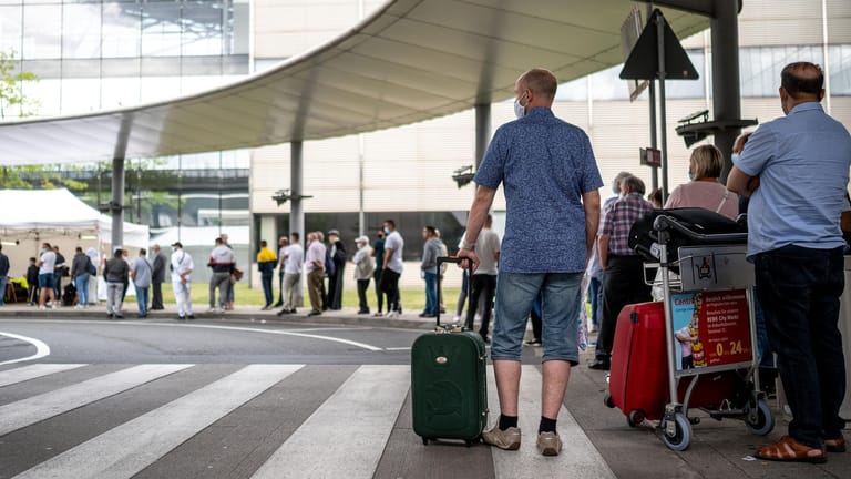 Flughafen Köln/Bonn: Reisende stehen am Corona-Testzentrum an.