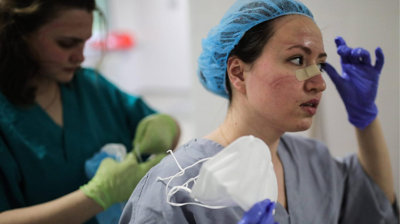 Krankenschwester mit Druckstellen: Wer stundenlang mit FFP-3-Maske und Schutzausrüstung arbeitet, leidet häufig unter wunden Stellen an Nase, Kinn und Stirn.
