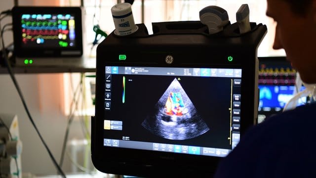 Ein Arzt untersucht das Herz eines Patienten mit Ultraschall. Ein Arzt untersucht das Herz eines Patienten mit Ultraschall.