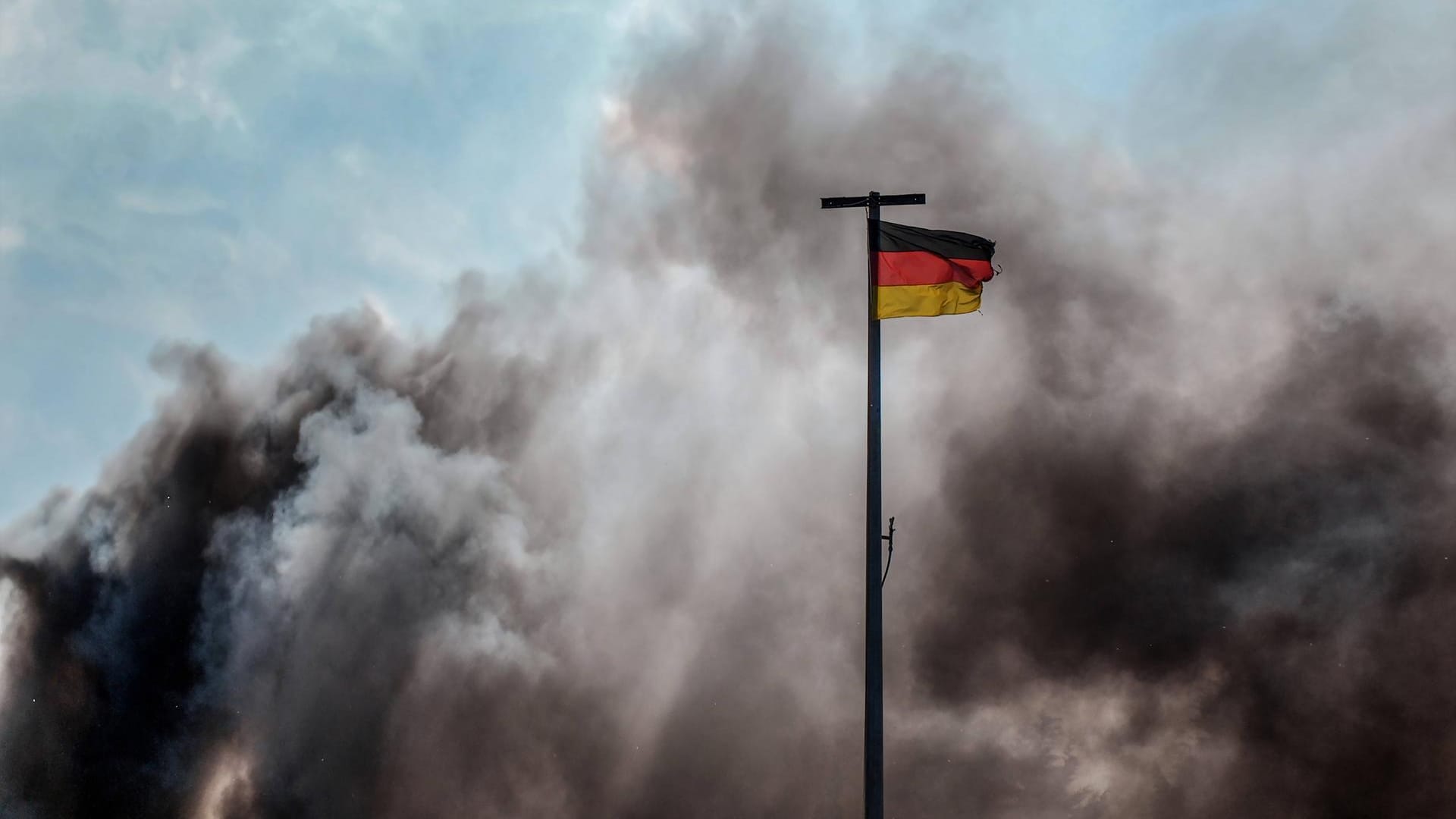 Eine Deutschlandfahne weht vor schwarzen Rauchwolken: In Berlin haben Unbekannte Deutschlandfahnen angezündet. Eine Deutschlandfahne weht vor schwarzen Rauchwolken: In Berlin haben Unbekannte Deutschlandfahnen angezündet.