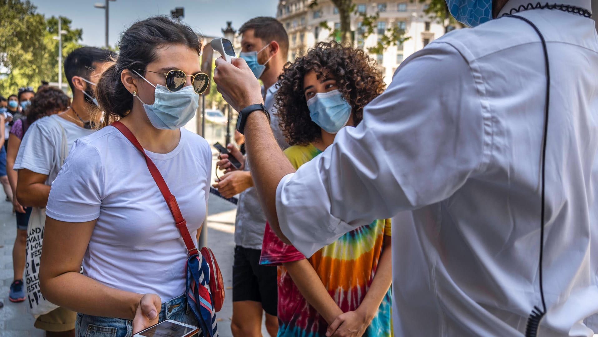 Bei Touristinnen wird vor einer Tour durch das Gaudí-Gebäude Casa Batlló in Barcelona die Temperatur gemessen: Das Auswärtige Amt rät derzeit von Reisen in die Stadt ab.