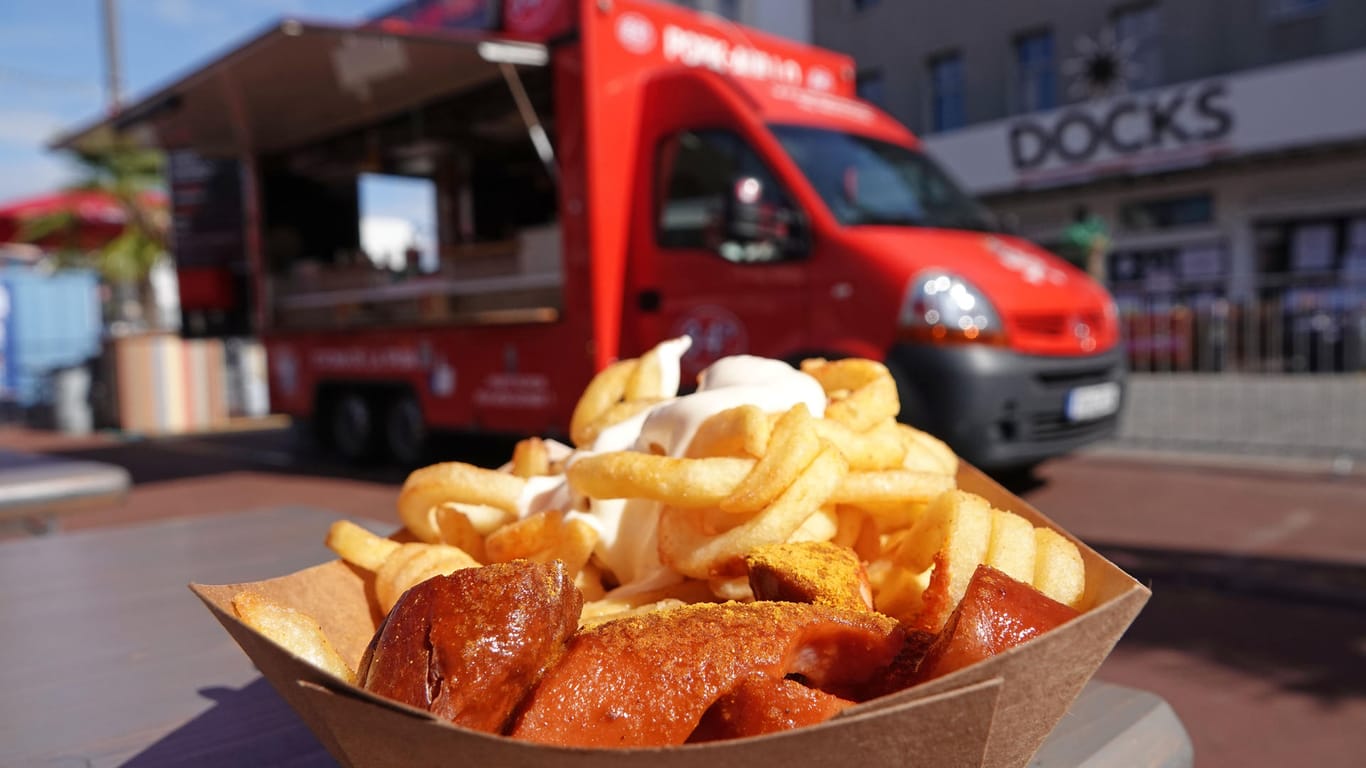 Eine Portion Currywurst mit Pommes ist vor einem Foodtruck zu sehen. Wegen der Corona-Krise warnen Gastronomen vor einer Pleitewelle in der Streetfoodszene.