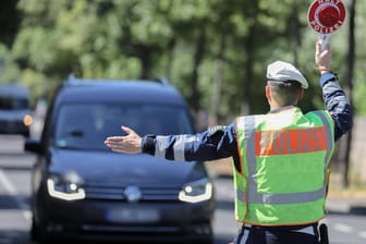 Ein Polizist hält einen Wagen zur Kontrolle an (Symbolbild): In Frankfurt war ein Jugendlicher ohne Fahrerlaubnis unterwegs