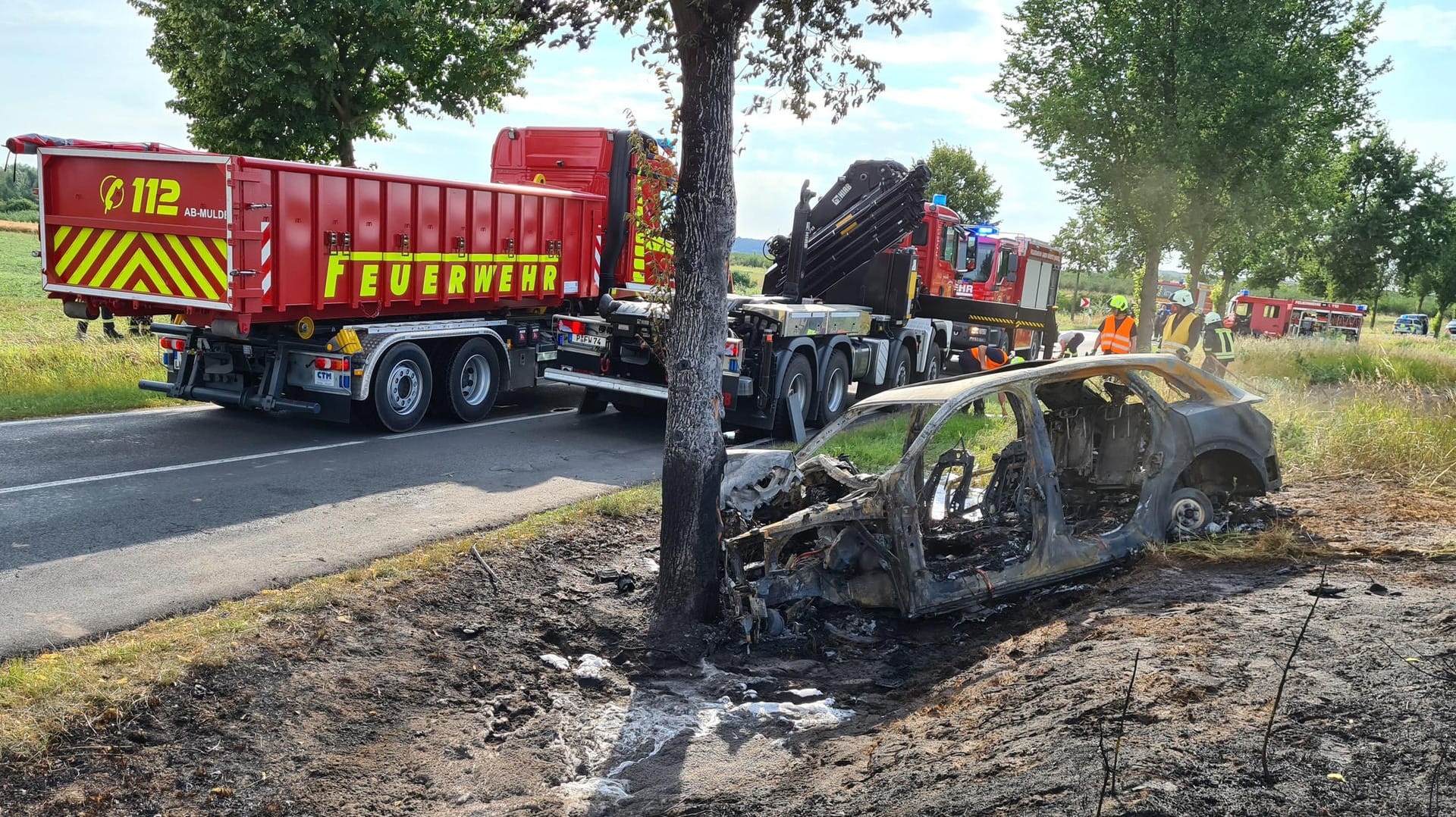 Das ausgebrannte Unfallwrack eines Autos: Eine junge Fahrerin ist in Groß Kreutz bei Potsdam mit dem Auto gegen einen Baum geprallt.