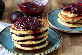 Der leckere Frühstücks-Stapel: Noch heißes Pflaumenkompott über den Pancakes und Pflaumen dazwischen.