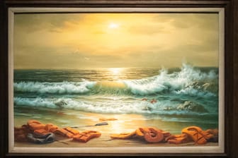 Ein Gemälde aus dem Triptychon mit dem Namen "Mediterranean Sea View 2017" des britischen Künstlers Banksy hängt im Auktionshaus Sotheby's: Das insgesamt aus drei Ölgemälden bestehende Werk zeigt eine Küste am Mittelmeer mit angespülten Rettungswesten.