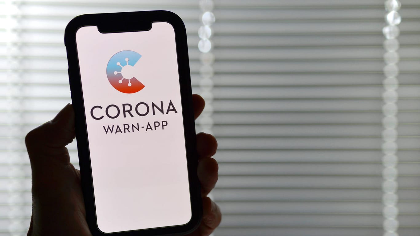 Eine Hand hält ein Smartphone mit der Corona-Warn-App (Symbolbild): Phoenix Hagen hat für die Nutzung der App geworben und sich Kritik von Fans anhören müssen.