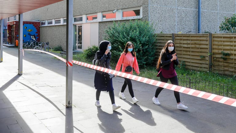 Drei Schülerinnen tragen Mundschutz auf dem Schulgelände (Symbolbild): In Berlin könnte schon bald eine Maskenpflicht an Schulen kommen.