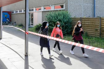 Drei Schülerinnen tragen Mundschutz auf dem Schulgelände (Symbolbild): In Berlin könnte schon bald eine Maskenpflicht an Schulen kommen.