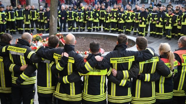 Mitglieder der Berufsfeuerwehr trauern nach der Gewalttat am Königsplatz in Augsburg. Mitglieder der Berufsfeuerwehr trauern nach der Gewalttat am Königsplatz in Augsburg.