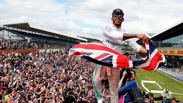 Der Mercedes-Formel-1-Pilot Lewis Hamilton feiert seinen Sieg mit dem Publikum auf dem Silverstone Circuit. Der Mercedes-Formel-1-Pilot Lewis Hamilton feiert seinen Sieg mit dem Publikum auf dem Silverstone Circuit.