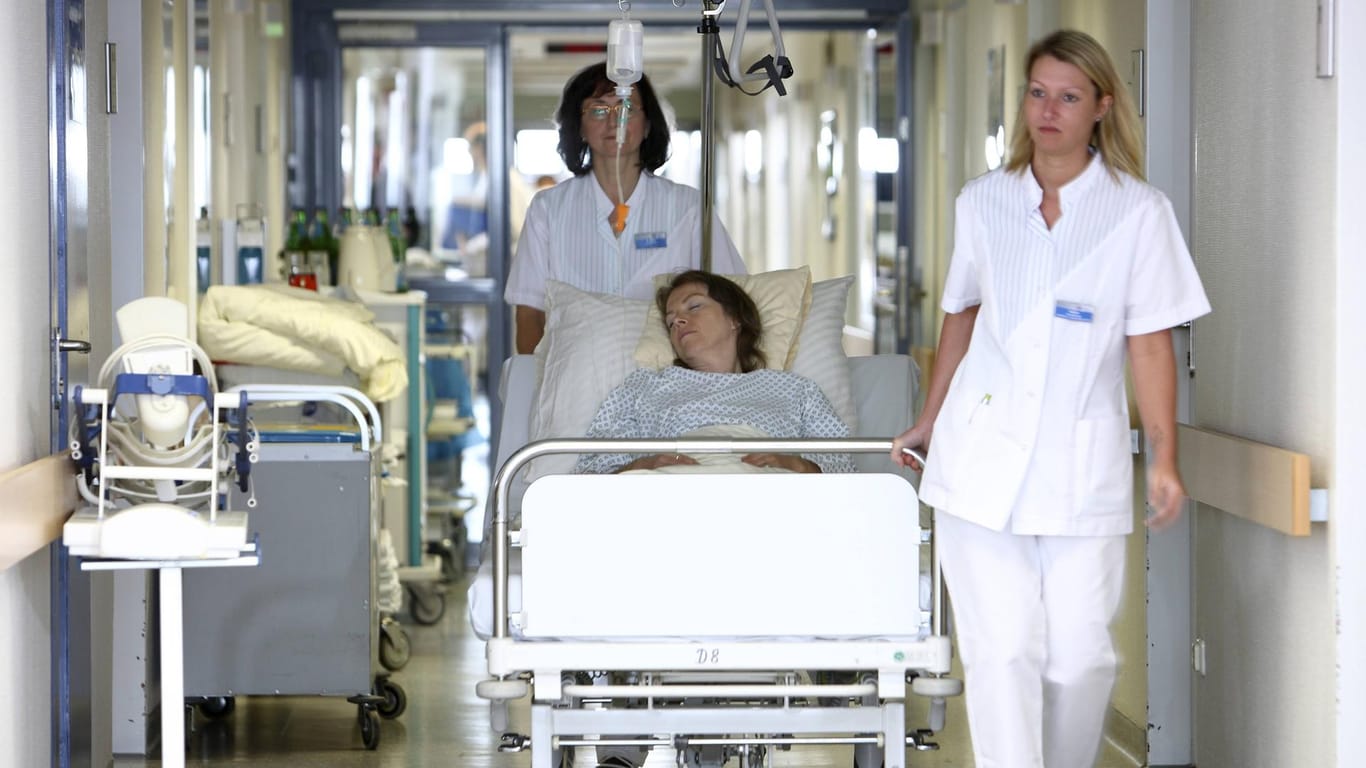 Krankenschwestern transportieren eine Patientin: Viele Pflegekräfte fordern bessere Arbeitsbedingungen für ihren Beruf.