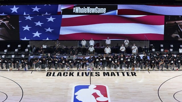 Die Spieler der New Orleans Pelicans und Utah Jazz knien bei der Nationalhymne gemeinsam vor einem "Black Lives Matter"-Schriftzug.