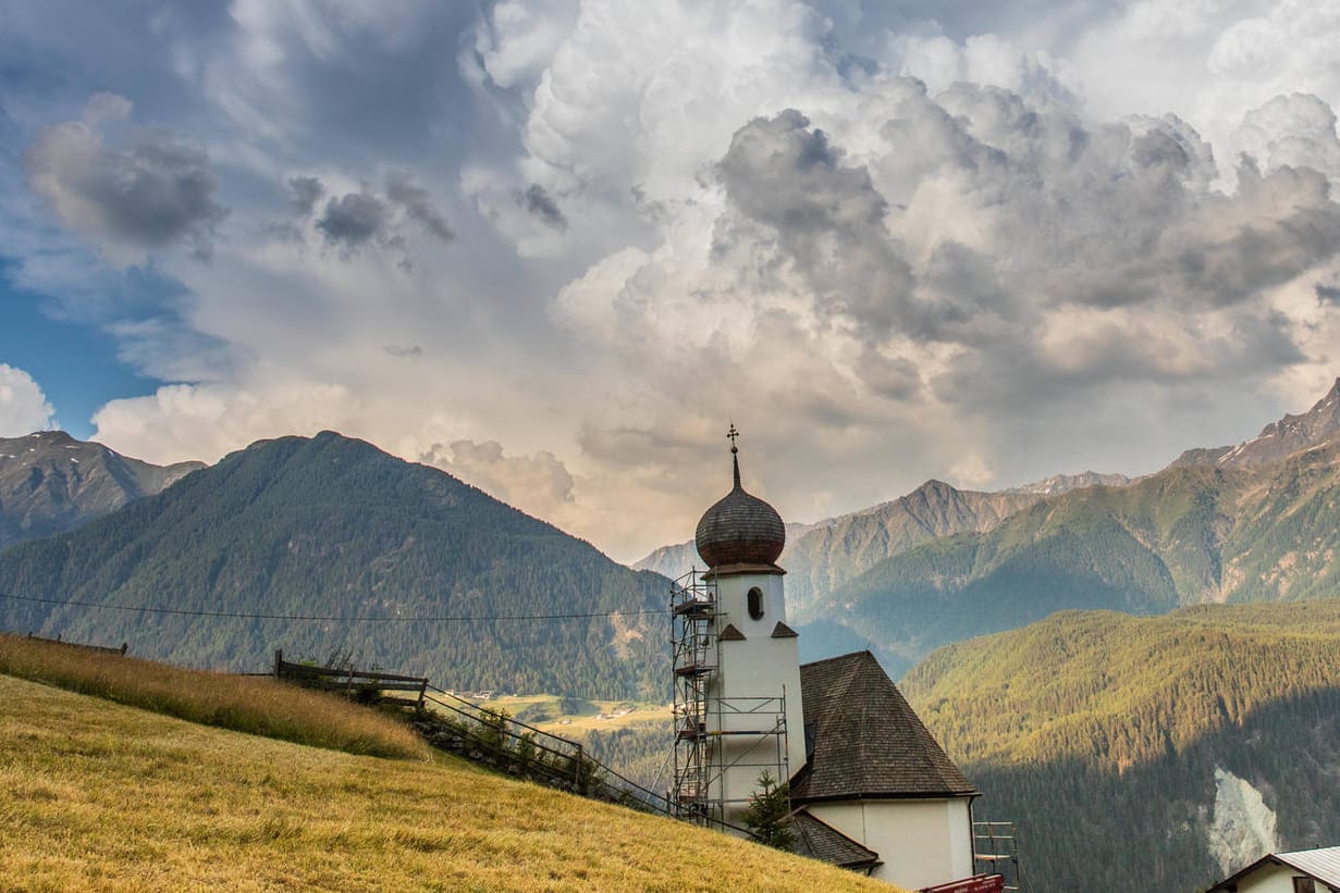 Über den Bergen braut sich ein Gewitter zusammen: Nach der Hitze folgen in vielen Teilen Deutschlands Gewitter und Schauer.