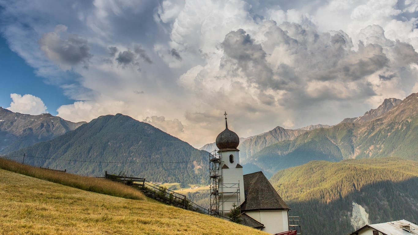 Über den Bergen braut sich ein Gewitter zusammen: Nach der Hitze folgen in vielen Teilen Deutschlands Gewitter und Schauer.