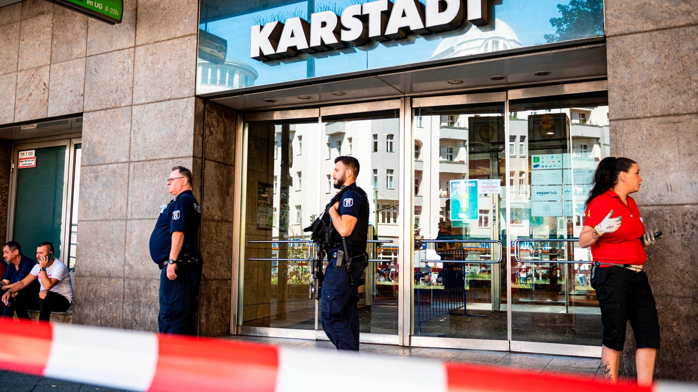 Schwer bewaffnete Polizeibeamte stehen an einem Kaufhaus am Hermannplatz: In Berlin-Neukölln war die Polizei wegen eines Raubüberfalls im Einsatz.