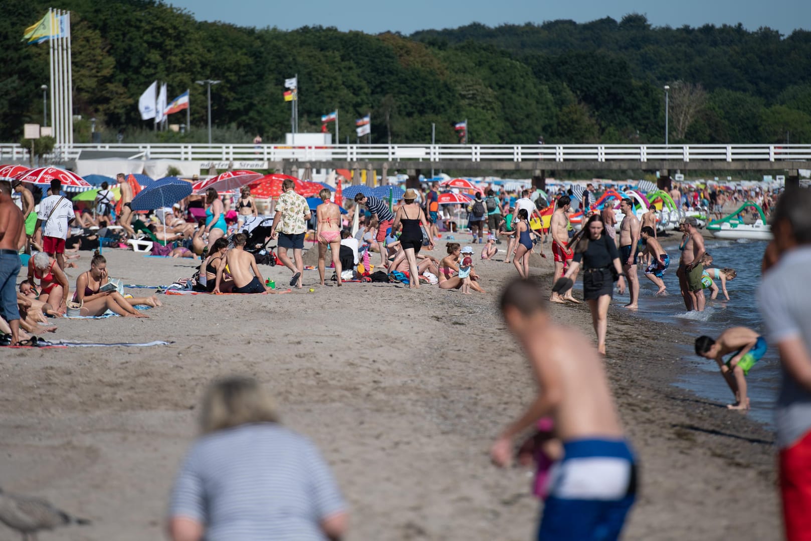 Timmendorfer Strand: Zahlreiche Menschen sind schon in den Morgenstunden am Ostseestrand unterwegs.