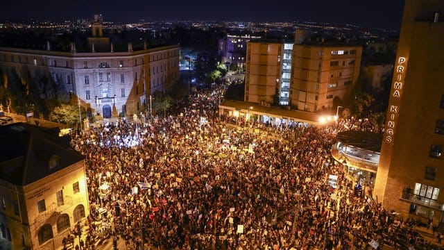Tausende Demonstranten nehmen an einem Protest gegen den israelischen Ministerpräsidenten Netanjahu nahe seiner Residenz in Jerusalem teil. Tausende Demonstranten nehmen an einem Protest gegen den israelischen Ministerpräsidenten Netanjahu nahe seiner Residenz in Jerusalem teil.