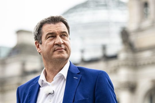 Markus Söder steht kurz vor dem Interview vor dem Reichstagsgebäude.