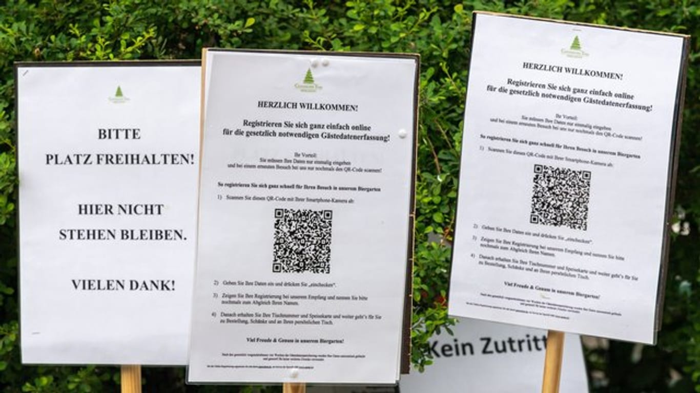 In der Corona-Krise: diverse Hinweisschilder vor einem Biergarten in Münchens Englischem Garten.