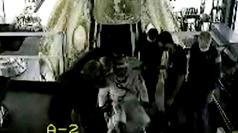 Das Videostandbild zeigt Astronaut Bob Behnken, dem beim Verlassen der Kapsel geholfen wird.