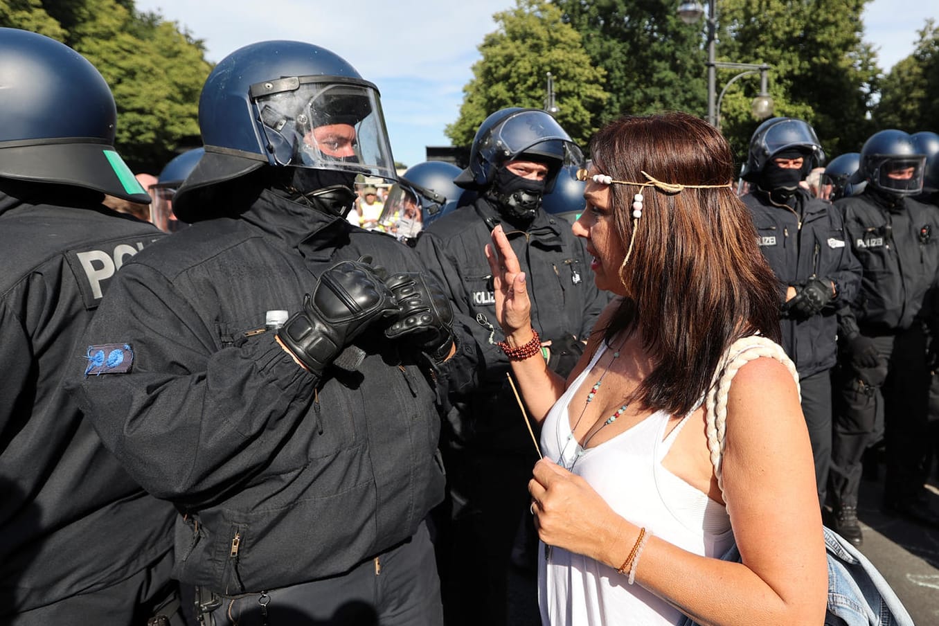 Eine Teilnehmerin der Corona-Demo in Berlin diskutiert mit einem Polizisten: Bei den Protesten wurden die Abstandsregeln nicht eingehalten.