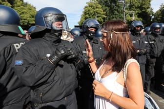Eine Teilnehmerin der Corona-Demo in Berlin diskutiert mit einem Polizisten: Bei den Protesten wurden die Abstandsregeln nicht eingehalten.