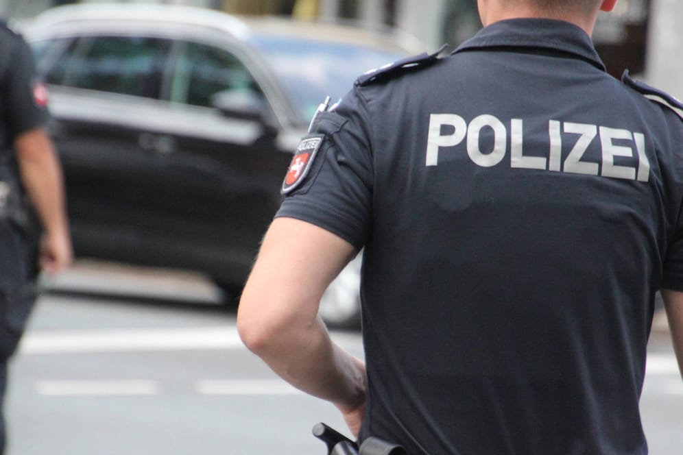 Ein Polizist steht mit dem Rücken zur Kamera (Symbolbild): Bei einer Auseinandersetzung in Wolfsburg musste die Polizei einschreiten.