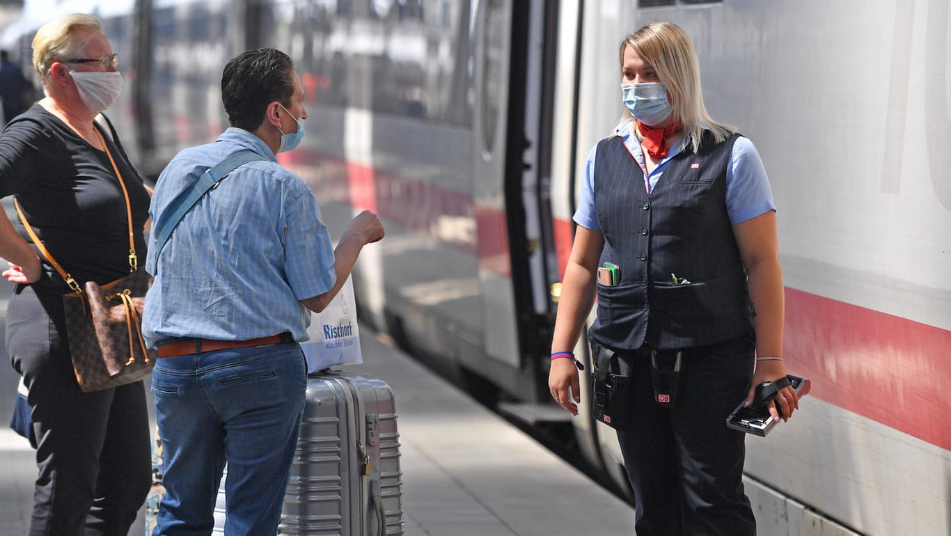 Eine Schaffnerin der Deutschen Bahn (r.) im Gespräch mit zwei Fahrgästen: Ohne Maske dürften sie im Zug nicht mitfahren.