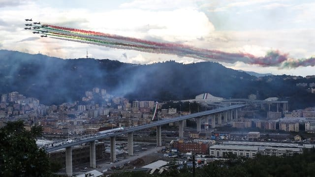 Die Kunstflugstaffel Frecce Tricolori fliegt bei der Einweihung in Genua über die neue Brücke hinweg. Die Kunstflugstaffel Frecce Tricolori fliegt bei der Einweihung in Genua über die neue Brücke hinweg.