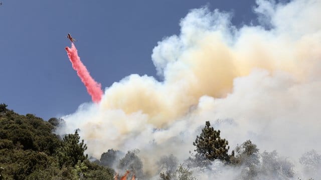 Feuerwehrleute kämpfen mit Unterstützung von Löschflugzeugen gegen den Waldbrand im Bezirk Riverside County. Feuerwehrleute kämpfen mit Unterstützung von Löschflugzeugen gegen den Waldbrand im Bezirk Riverside County.