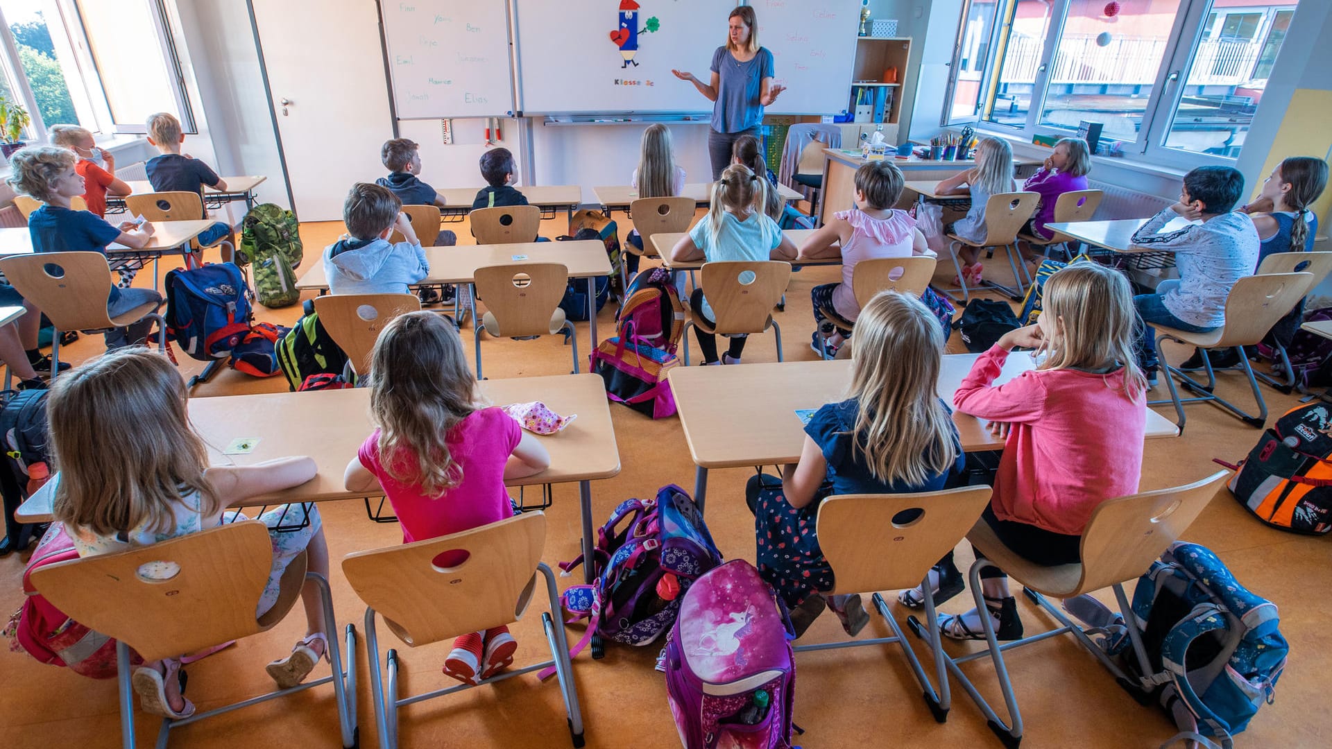 Eine Lehrerin der Grundschule Lankow in Schwerin begrüßt ihre Schüler.