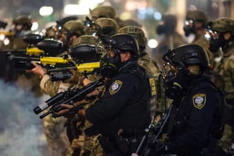Polizisten bahnen sich ihren Weg durch Tränengas-Wolken: Amnesty International äußert Bedenken an der Rechtsstaatlichkeit in den USA.