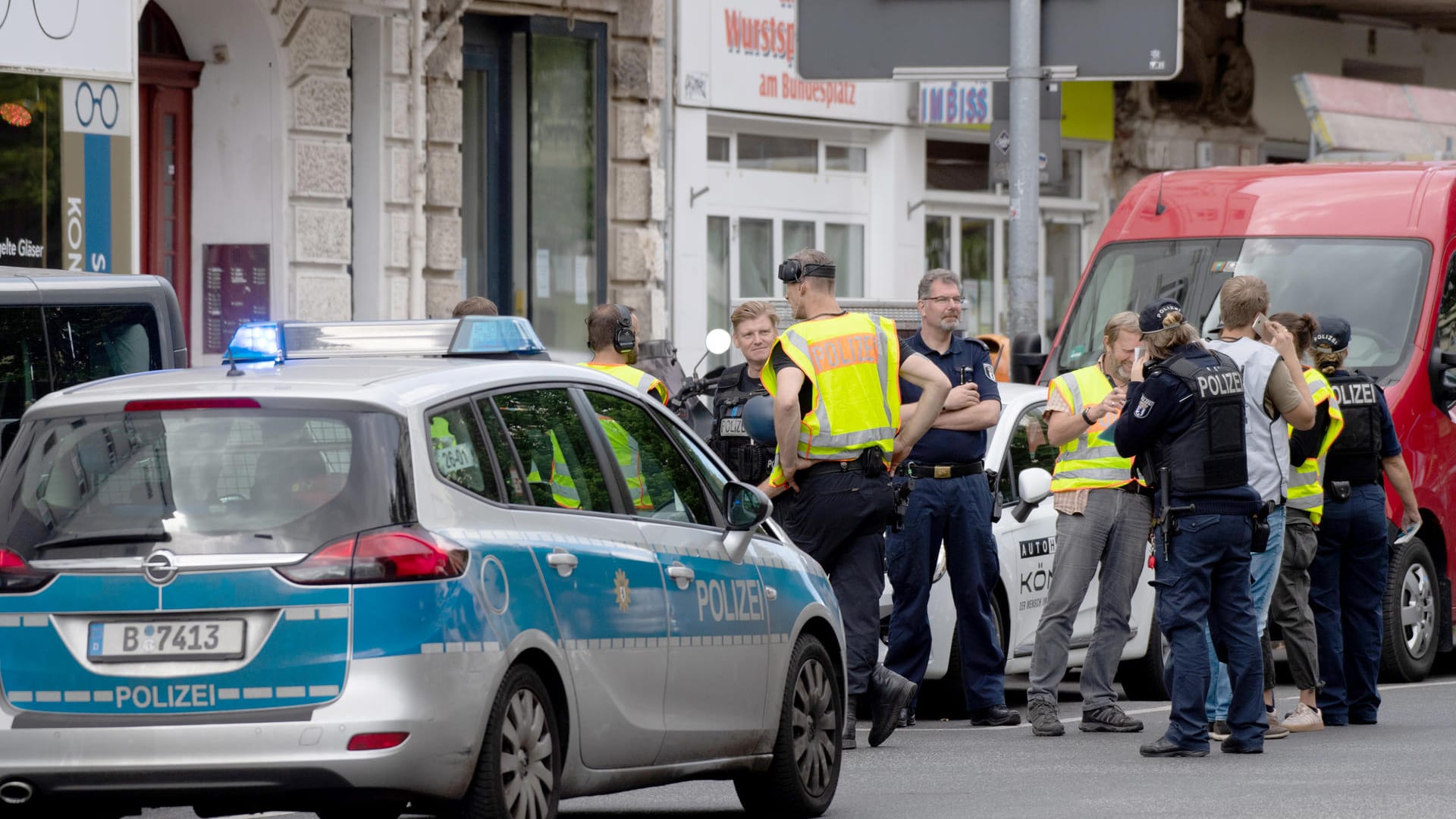 Polizisten und Feuerwehrleute stehen vor einer Bank in Berlin-Wilmersdorf: Maskierte Täter sind mit einem Auto in die Filiale gerast.