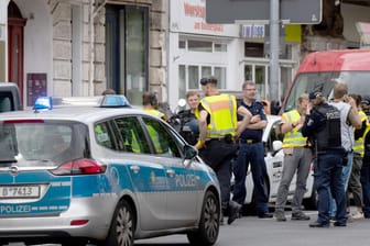Polizisten und Feuerwehrleute stehen vor einer Bank in Berlin-Wilmersdorf: Maskierte Täter sind mit einem Auto in die Filiale gerast.