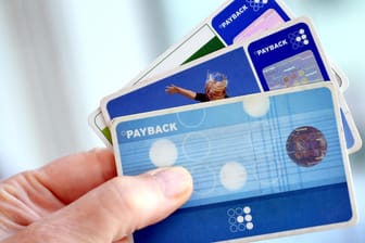 Eine Hand hält mehrere Payback-Karten: Vor allem bei den Prämien sollten Nutzer wachsam sein.