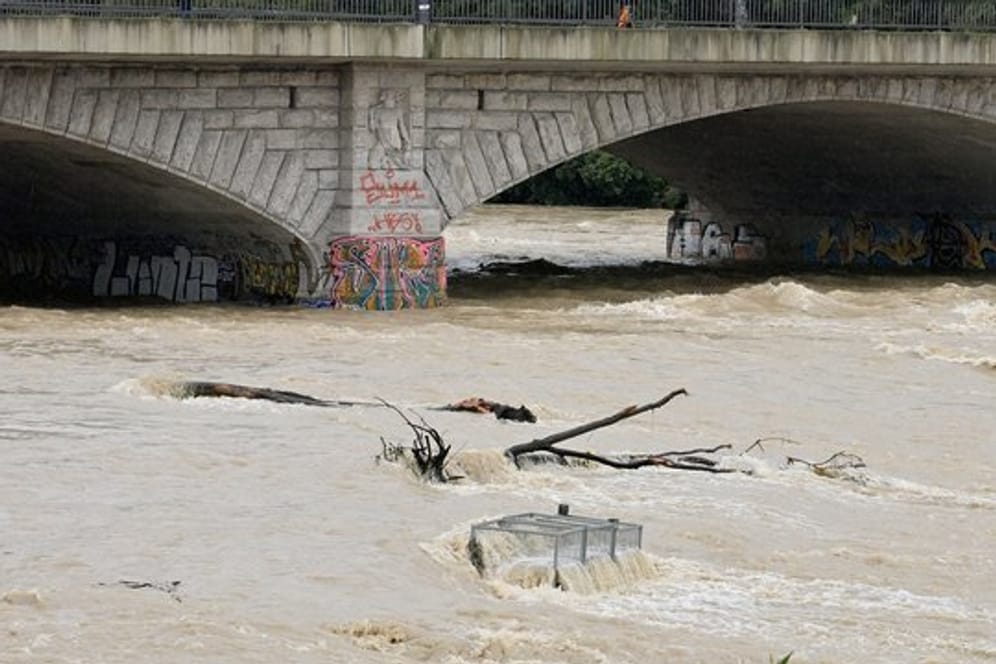 Nach starkem Regen fließt braunes Wasser unter der Reichenbachbrücke durch das Flussbett der Isar in München.