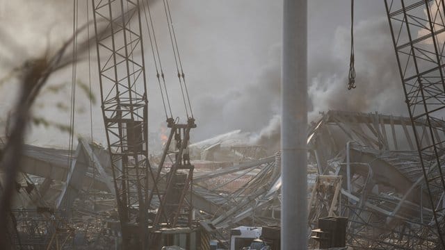 Rauch steigt nach einer Explosion über den Trümmern eines zerstörten Gebäudes auf.