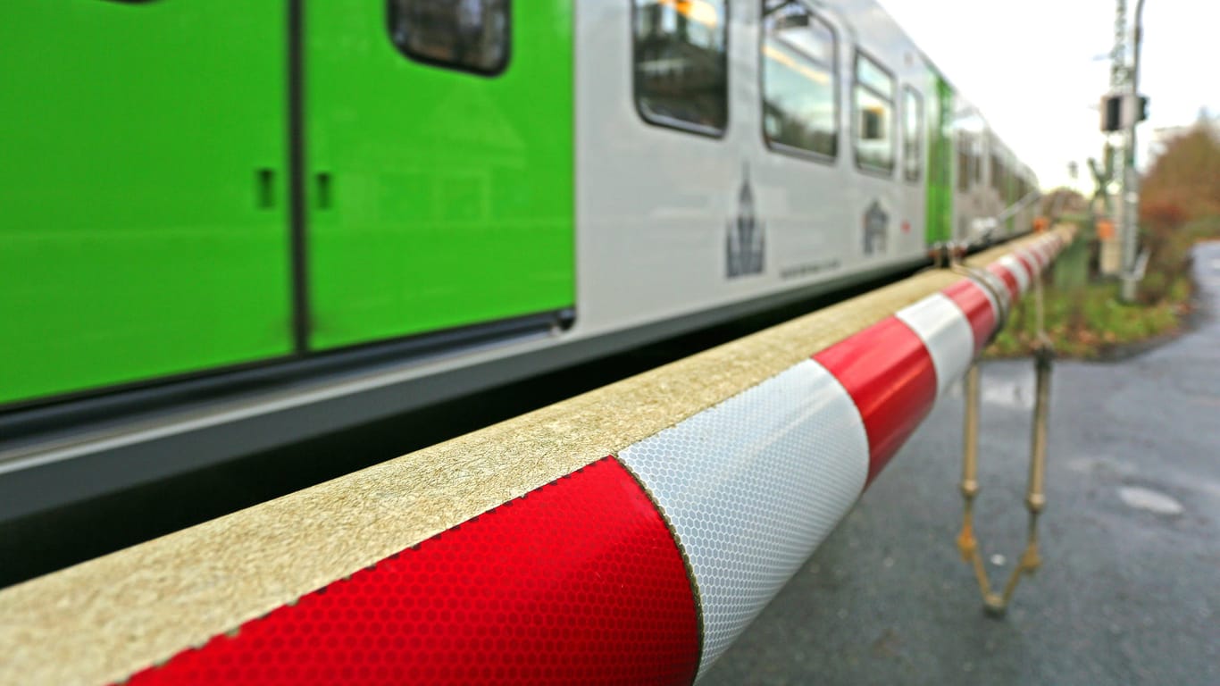 Eine Bahn überquert einen Bahnübergang mit heruntergelassenen Schranken (Symbolbild): Eine 35-Jährige wurde in Bonn von einer Straßenbahn erfasst.