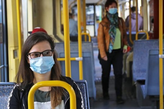 Fahrgäste einer Kölner Stadtbahn tragen Schutzmasken.