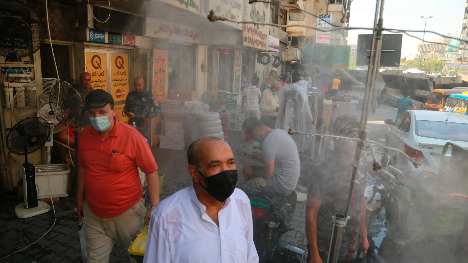 Bagdad, Irak: Menschen kühlen sich unter Freiluftduschen in den Straßen von Bagdad ab.