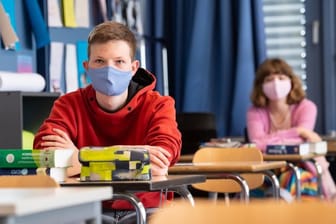 Schüler und Schülerinnen eines Gymnasiums tragen Mundschutze.