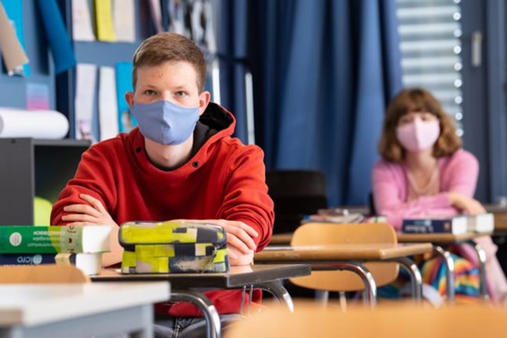 Schüler und Schülerinnen eines Gymnasiums tragen Mundschutze.