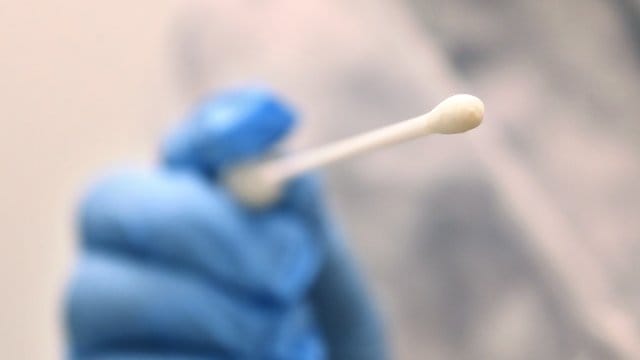 Ein Arzt hält in einer Hausarztpraxis einen Tupfer für einen Coronatest-Abstrich. Ein Arzt hält in einer Hausarztpraxis einen Tupfer für einen Coronatest-Abstrich.