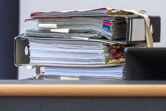 Akten in einem Gerichtssaal: Bayerns Sozialgerichte ziehen Corona-Zwischenbilanz.