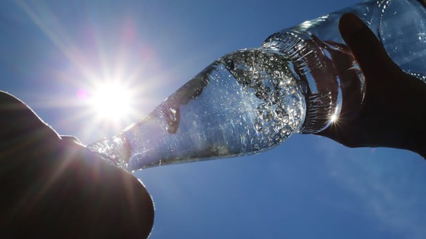 Eine Frau trinkt aus einer Flasche Mineralwasser