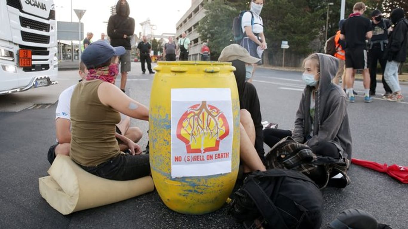 Umweltaktivisten sitzen vor der Zufahrt zur Shell-Raffinerie in Wesseling bei Köln: Sie haben zusätzlich mit Kajaks die Hafen-Zufahrt im Godorfer Hafen im Kölner Stadtgebiet blockiert.